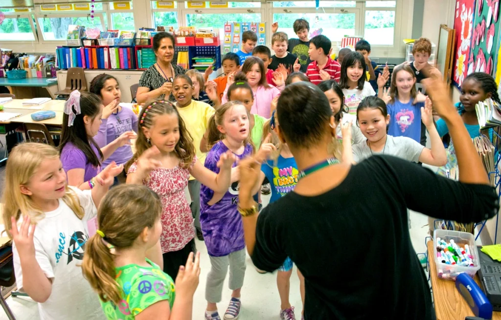 A female teacher leads students in a fun, engaging activity during Morning Meeting