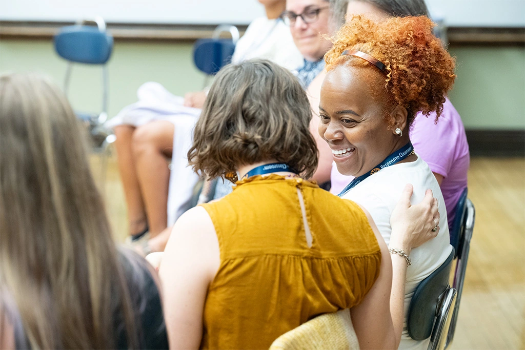 Teachers chat with one another while participating in a Morning Meeting during a Responsive Classroom in-person training